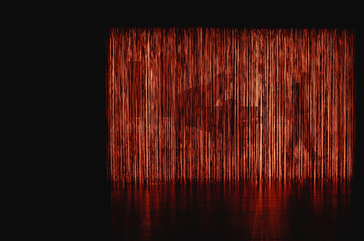 A grand piano on a dramatically lit concert stage